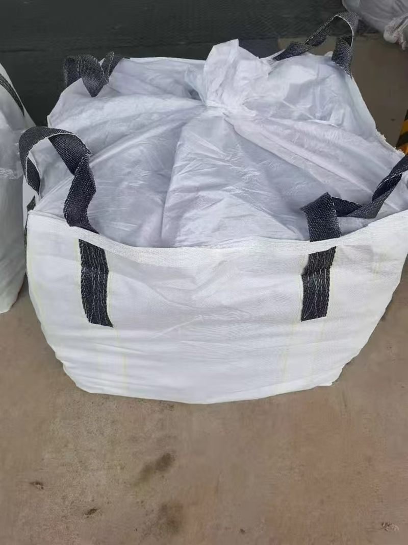 A filled white export bulk bag with four black lifting loops