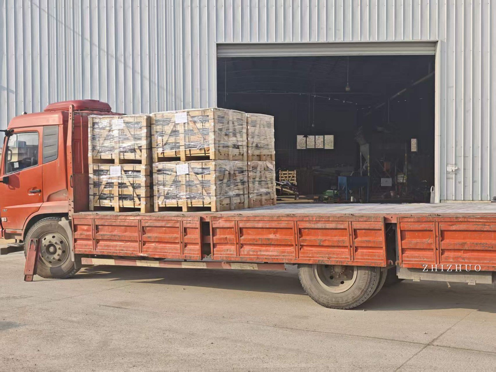 Wrapped wooden crates of black pebbles loaded on a flatbed truck for export from China