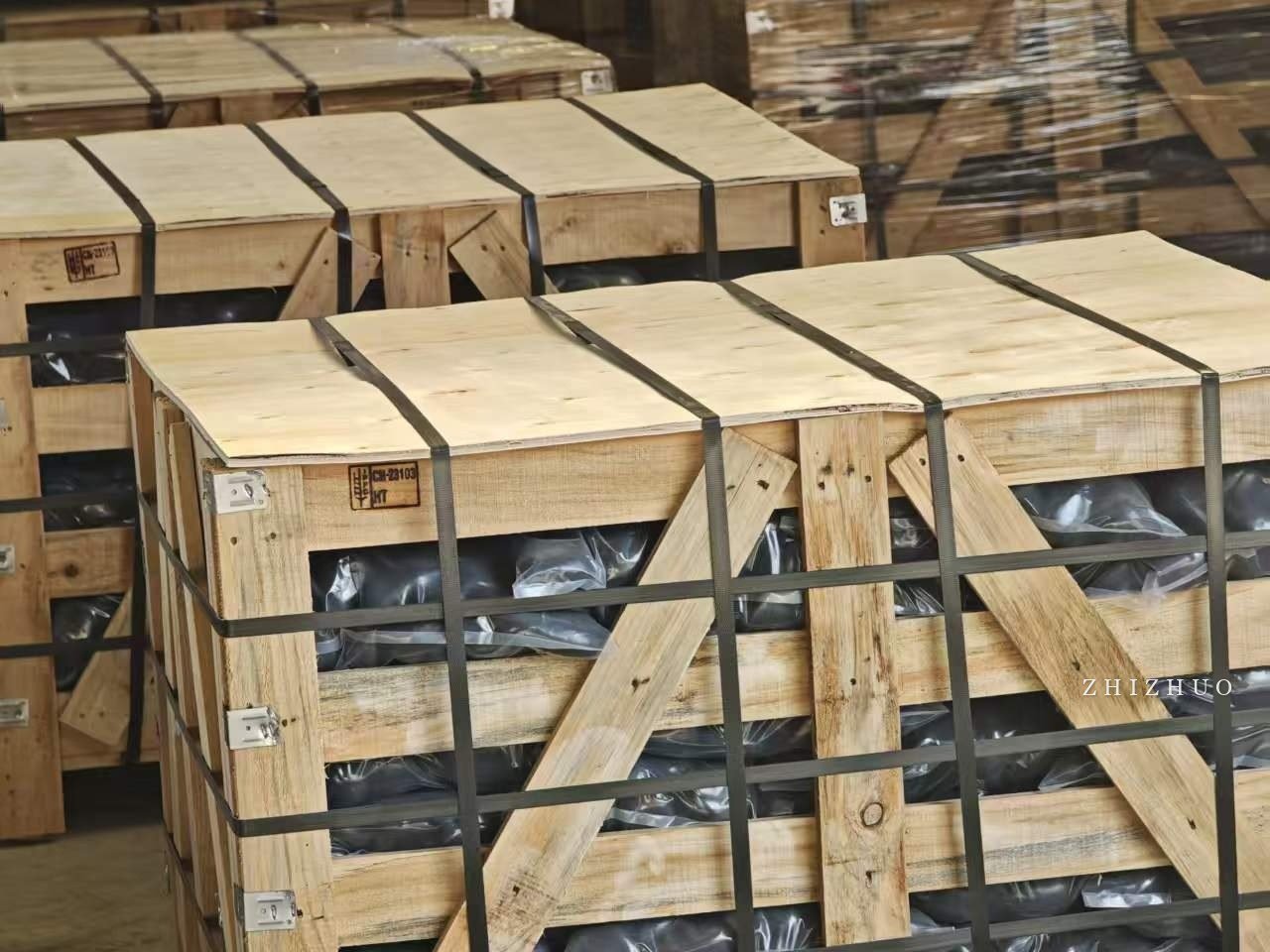 Packed black pebble inventory in strapped wooden crates, ready for international supply