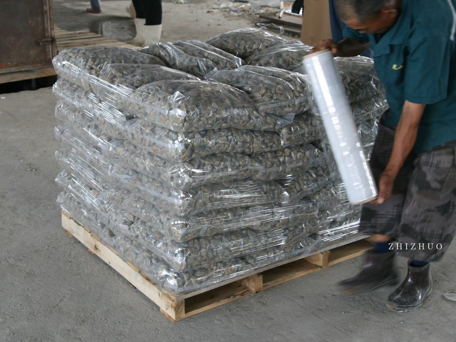 Decorative stone bags being stretch-wrapped on a pallet for export