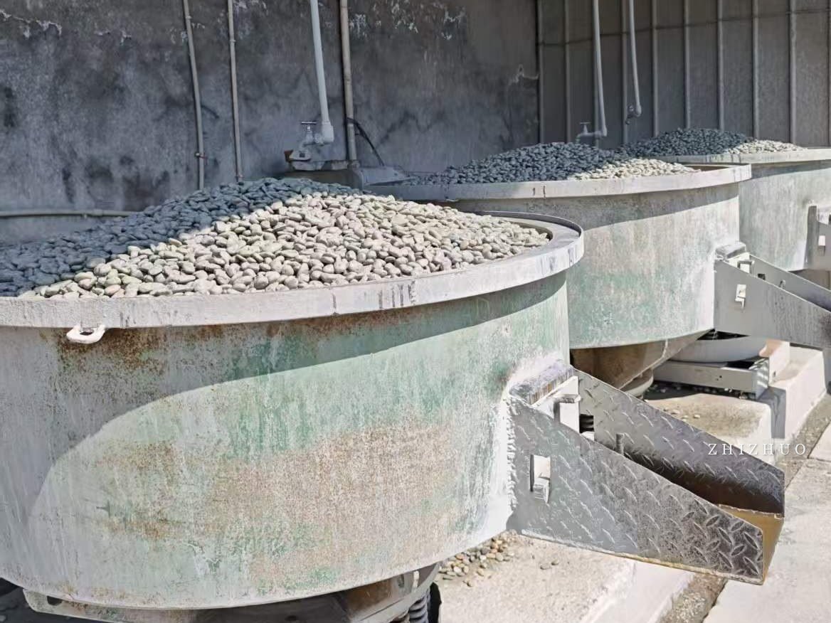 Vibratory tumbling machines loaded with pebbles at a stone processing plant in China